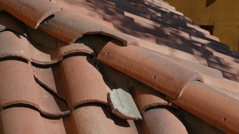 Broken clay roof tiles exposing the underlay beneath