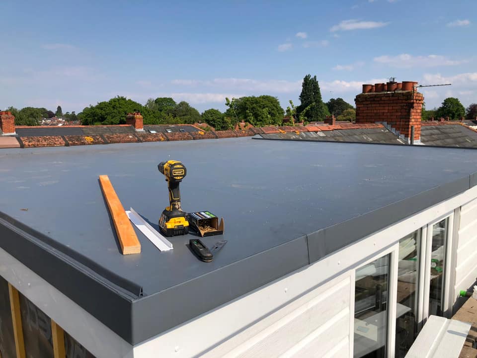 Roofer working on a grey GRP fibreglass flat roof
