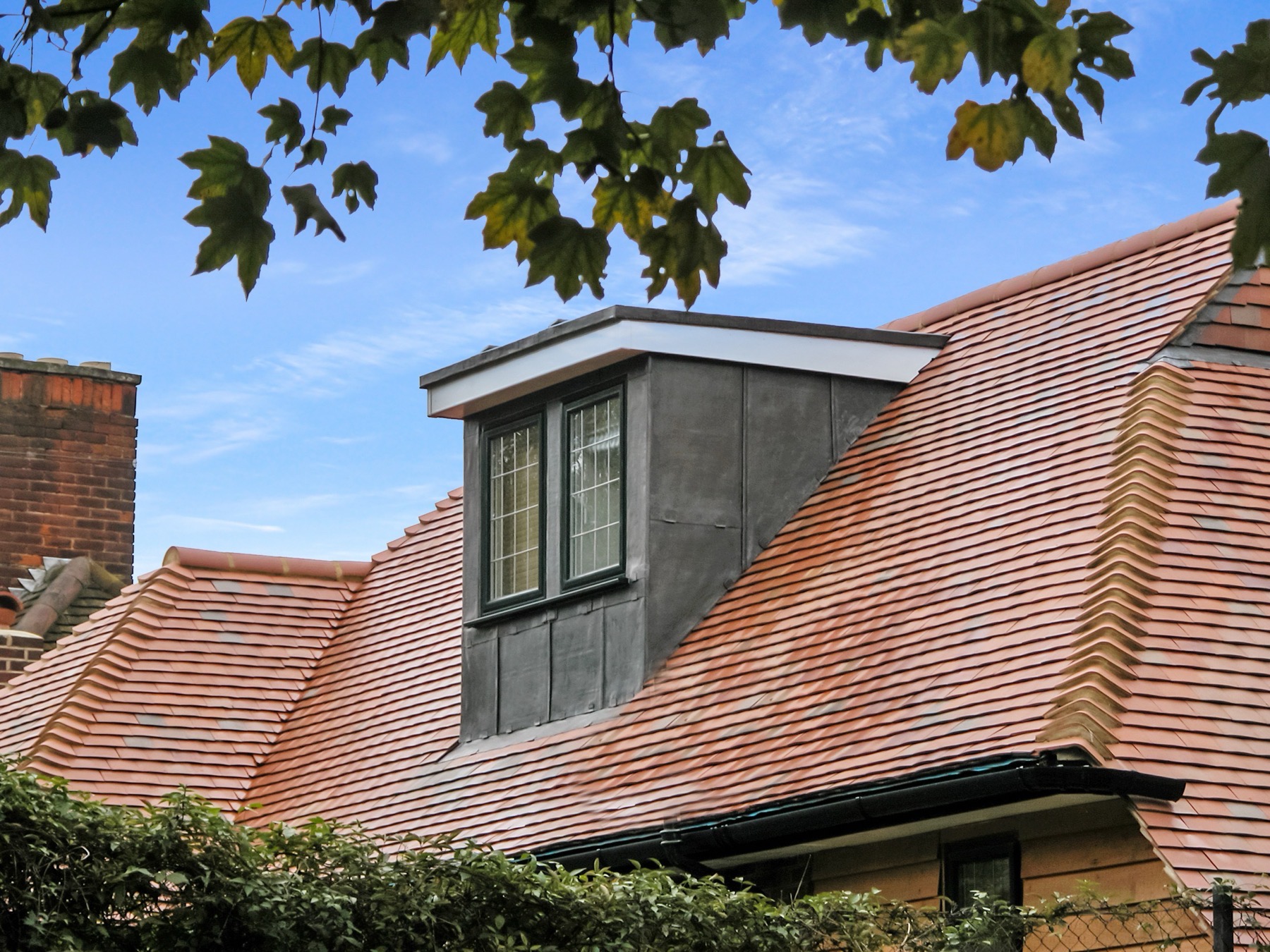 Modern lead-clad dormer on a red clay tiled roof