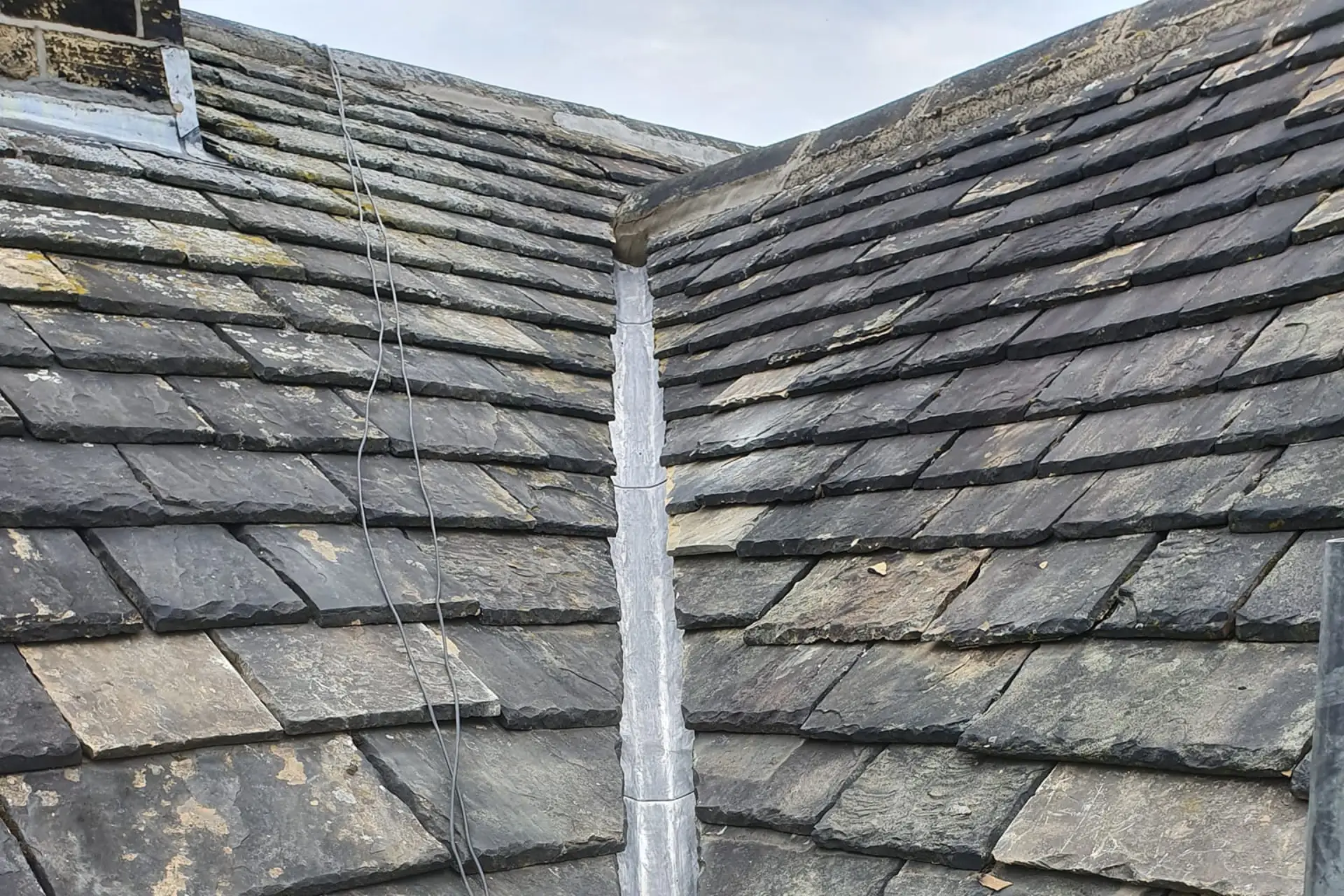 Stone slate roof valley lined with new lead