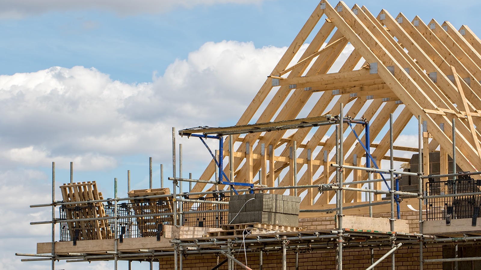 Wooden roof trusses and scaffolding at the start of an EJL re-roof