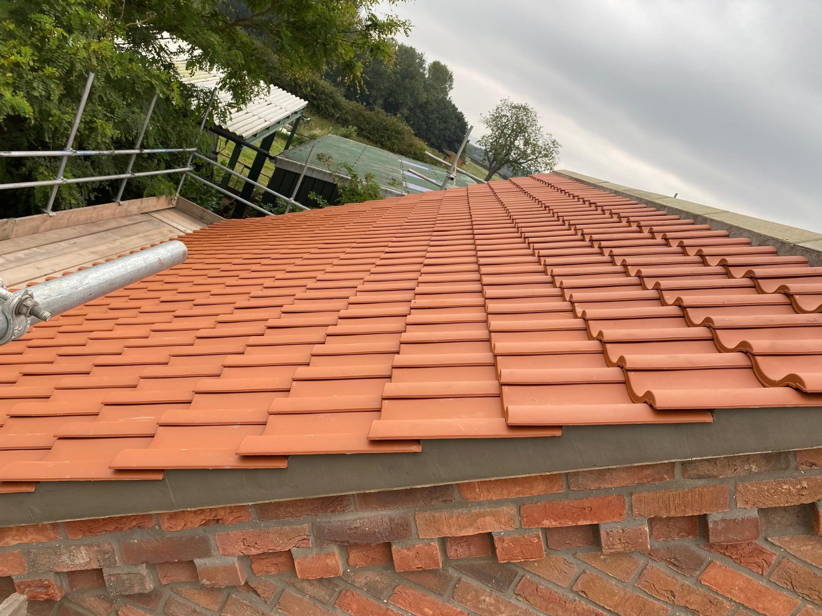 Newly laid clay roof tiles with scaffolding on a York job by EJL Roofing