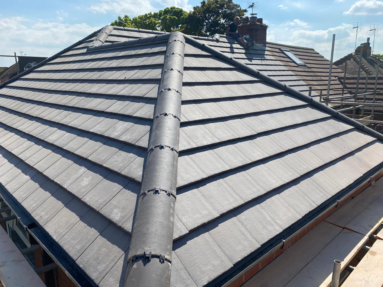 Finished grey concrete tile roof with a dry ridge system on a modern house